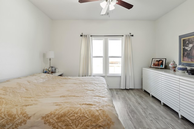 bedroom featuring ceiling fan, baseboards, and light wood-style floors