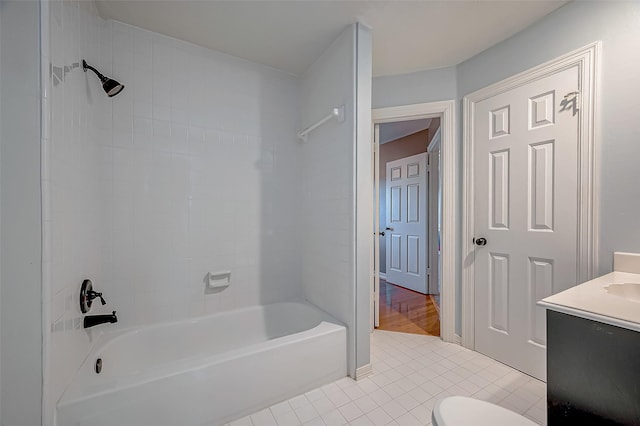 bathroom featuring tile patterned flooring, toilet, vanity, baseboards, and washtub / shower combination