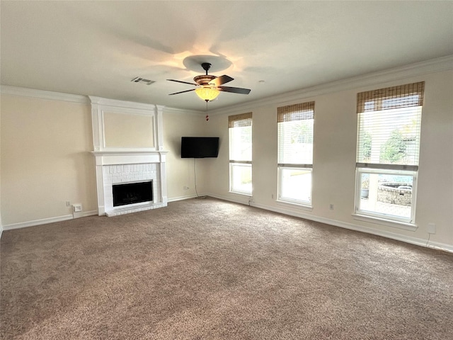 unfurnished living room featuring carpet floors, a brick fireplace, crown molding, and a ceiling fan