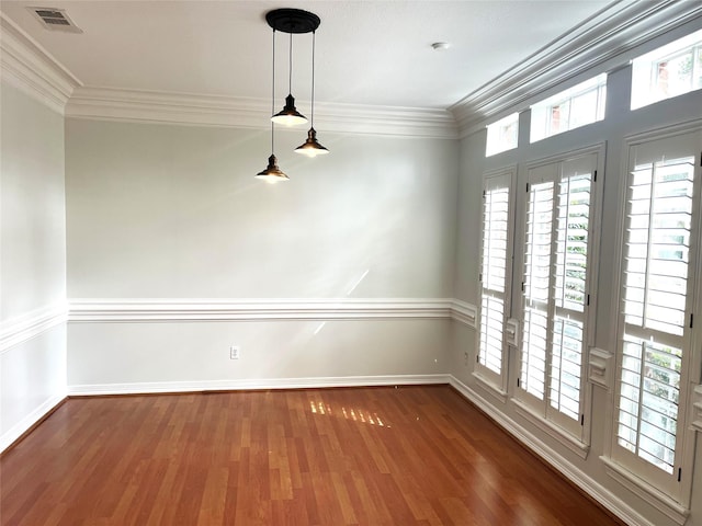 unfurnished room featuring plenty of natural light, dark wood finished floors, visible vents, and crown molding