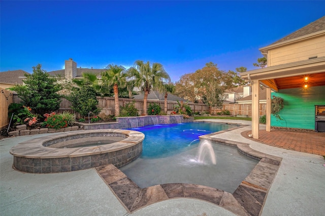 view of swimming pool featuring a patio area, a fenced backyard, and a pool with connected hot tub