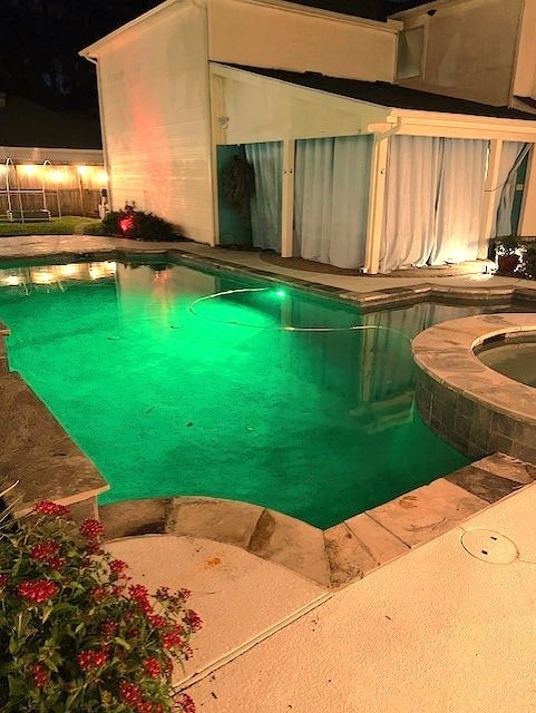 view of pool with a fenced in pool and an in ground hot tub