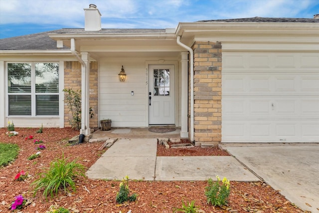 property entrance featuring stone siding, brick siding, a chimney, and an attached garage