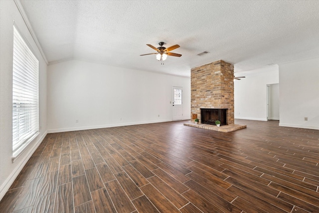 unfurnished living room with lofted ceiling, dark wood-type flooring, a fireplace, visible vents, and a ceiling fan