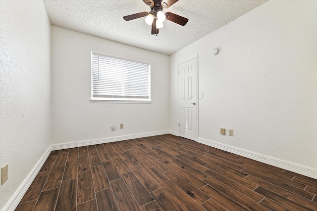 empty room featuring dark wood finished floors, a textured ceiling, baseboards, and ceiling fan