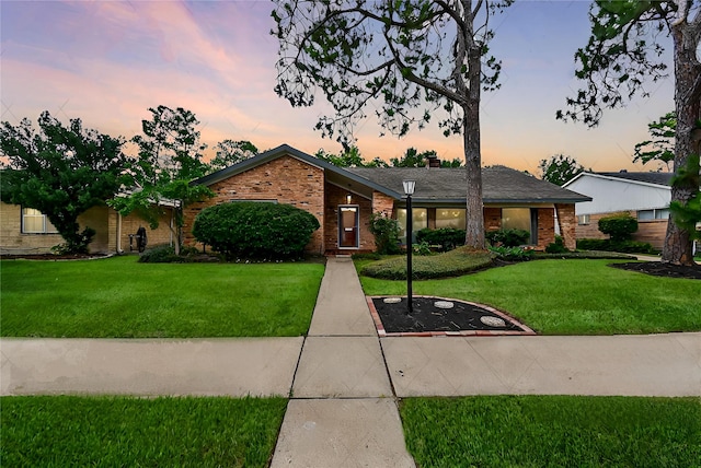 mid-century modern home featuring brick siding and a front lawn