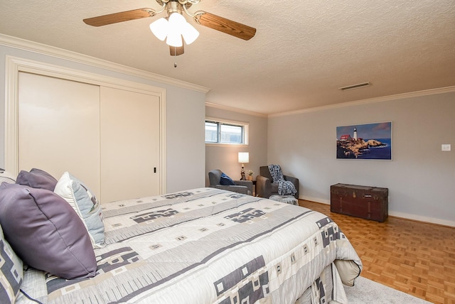 bedroom featuring ornamental molding, visible vents, a textured ceiling, and a ceiling fan