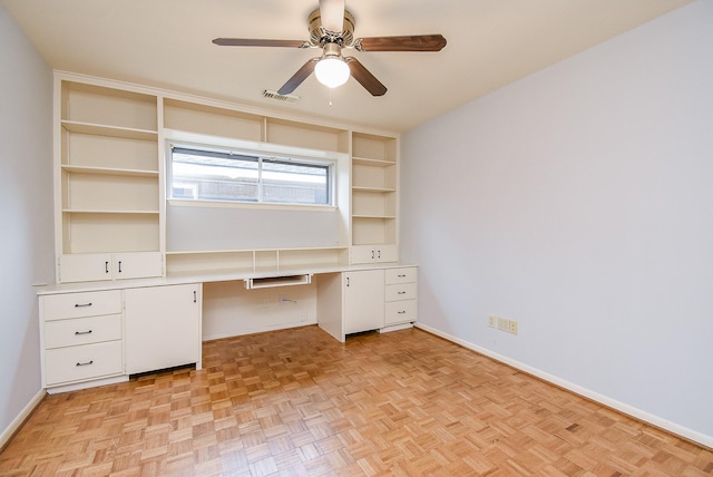 unfurnished office featuring visible vents, baseboards, a ceiling fan, and built in study area