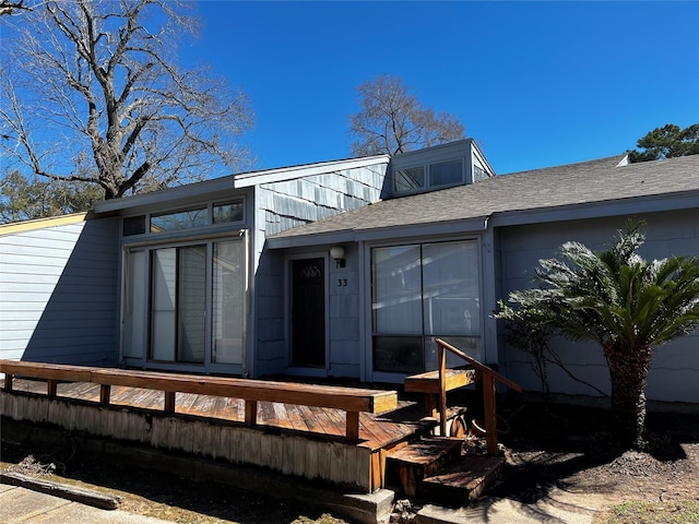 view of front of property featuring roof with shingles and a deck