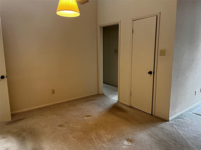 carpeted empty room featuring baseboards