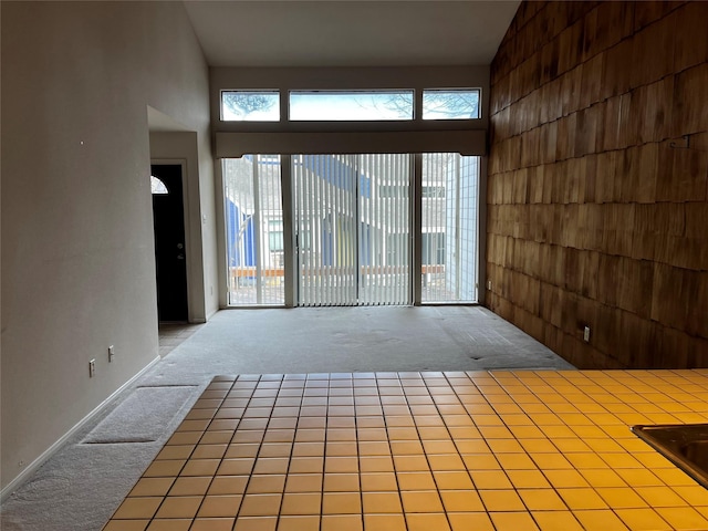 unfurnished room with a towering ceiling and carpet