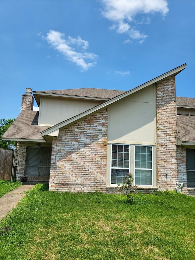 view of front facade featuring a chimney and brick siding