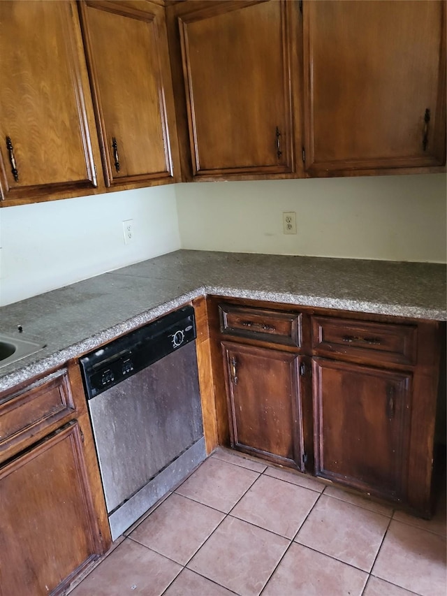 kitchen with light tile patterned floors and stainless steel dishwasher