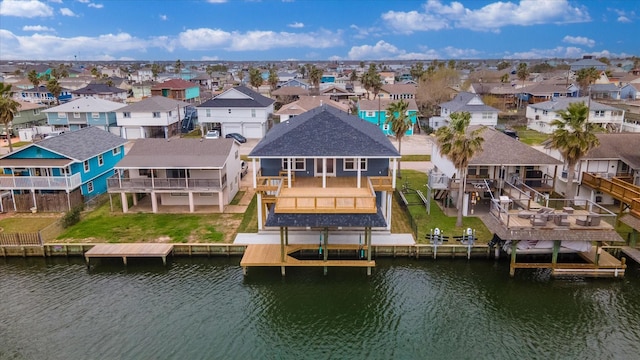 rear view of property with a water view, boat lift, and a residential view