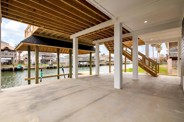 view of patio / terrace featuring stairway, a dock, and a water view