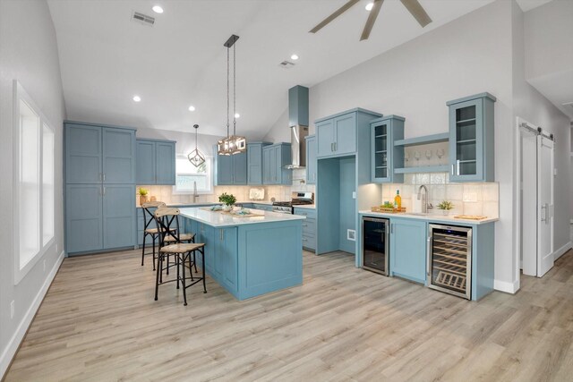 kitchen with blue cabinets, beverage cooler, glass insert cabinets, and light countertops