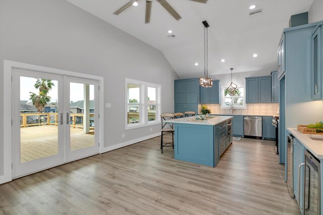 kitchen featuring light countertops, stainless steel dishwasher, a breakfast bar, and blue cabinets