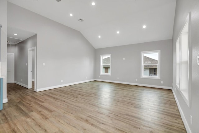 unfurnished living room featuring attic access, visible vents, light wood-style floors, and baseboards