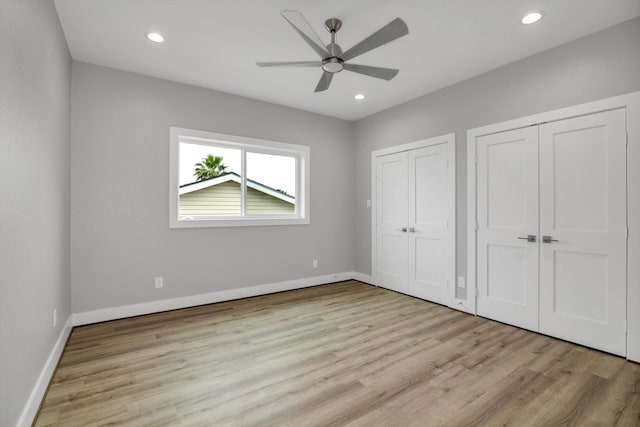 unfurnished bedroom with multiple closets, recessed lighting, baseboards, and light wood finished floors