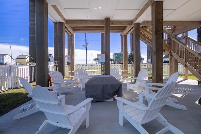 view of patio / terrace featuring fence and stairs