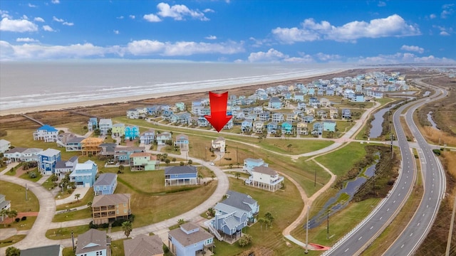 drone / aerial view with a water view, a residential view, and a view of the beach