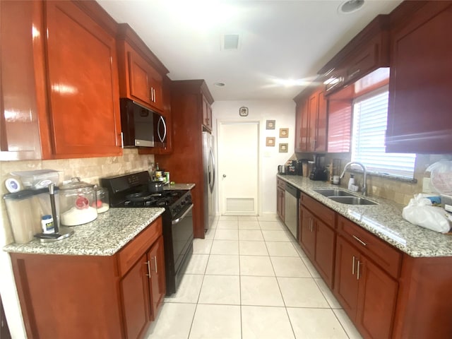 kitchen with visible vents, decorative backsplash, appliances with stainless steel finishes, a sink, and light stone countertops