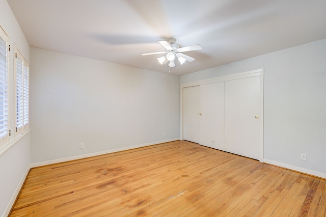 unfurnished bedroom featuring baseboards, ceiling fan, a closet, and light wood-style floors