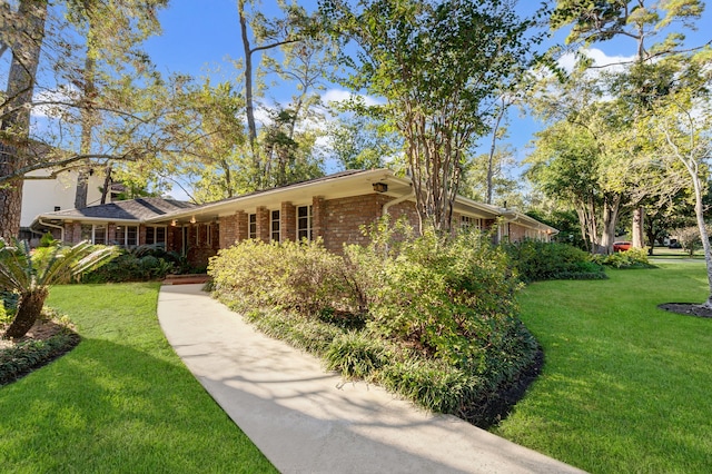 view of front facade with brick siding and a front lawn