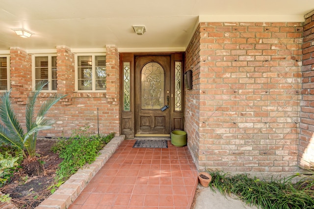 view of exterior entry with brick siding