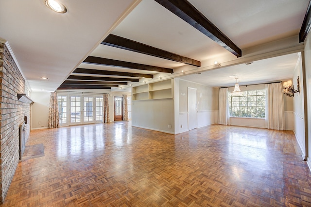 unfurnished living room featuring a fireplace, baseboards, and beamed ceiling