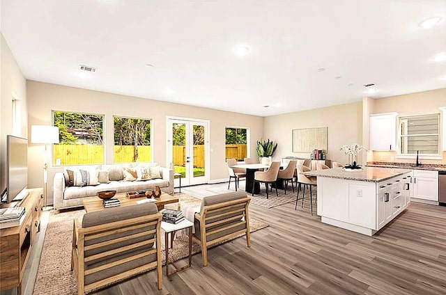 living room with recessed lighting, visible vents, wood finished floors, and french doors