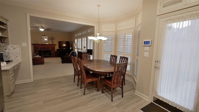 dining room with a brick fireplace, wood tiled floor, and ornamental molding