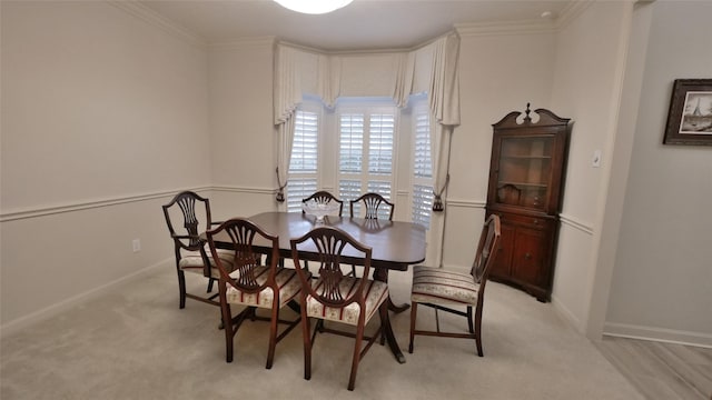 dining area featuring ornamental molding, light carpet, and baseboards