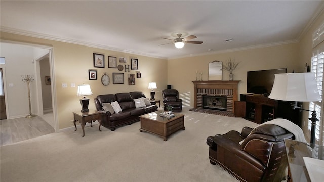 living area featuring a ceiling fan, crown molding, and light colored carpet