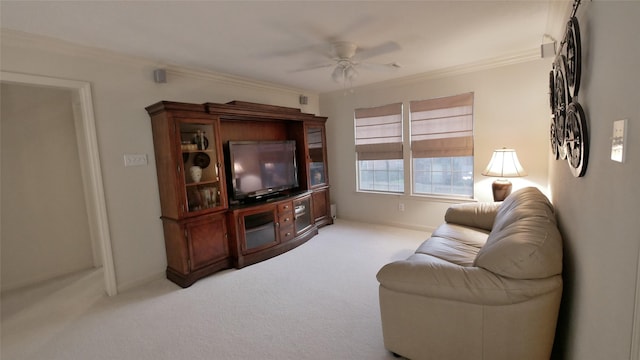 living area with ceiling fan, ornamental molding, and light colored carpet