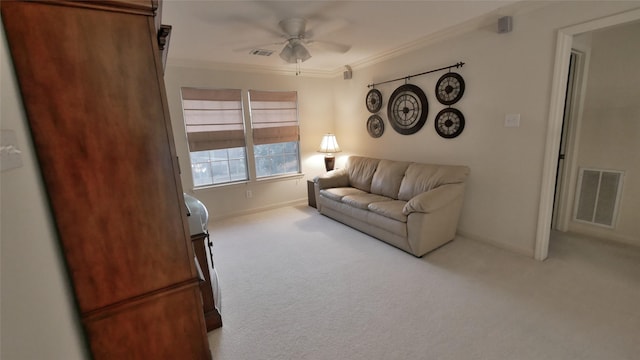 living room featuring ceiling fan, visible vents, ornamental molding, and light colored carpet