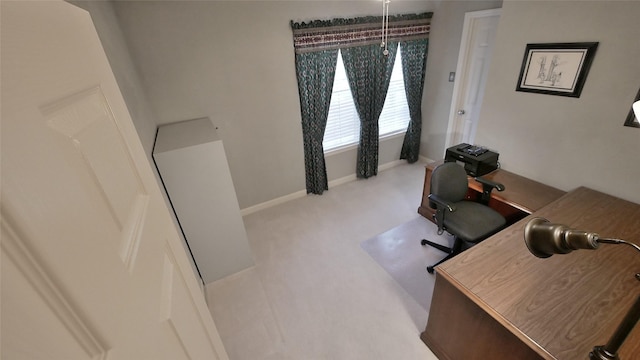 office area featuring light carpet and baseboards