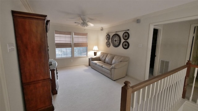 living room featuring ceiling fan, visible vents, ornamental molding, and light colored carpet