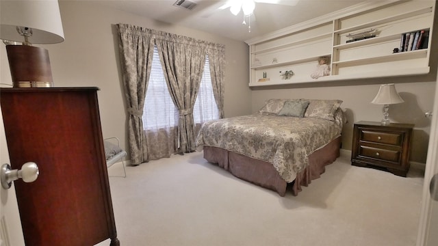 carpeted bedroom featuring visible vents and a ceiling fan