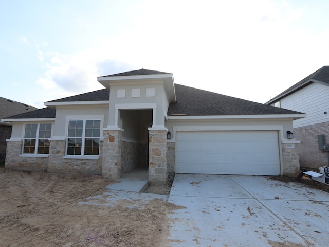 8311 Oceanmist Cove Dr, Cypress, TX 77433 - prairie-style home with stone siding, concrete driveway, an attached garage, roof with shingles, and stucco siding