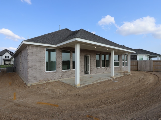 8311 Oceanmist Cove Dr, Cypress, TX 77433 - back of house with brick siding, a patio, a shingled roof, and cooling unit