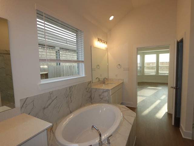 8311 Oceanmist Cove Dr, Cypress, TX 77433 - full bathroom with a garden tub, vaulted ceiling, vanity, and wood finished floors