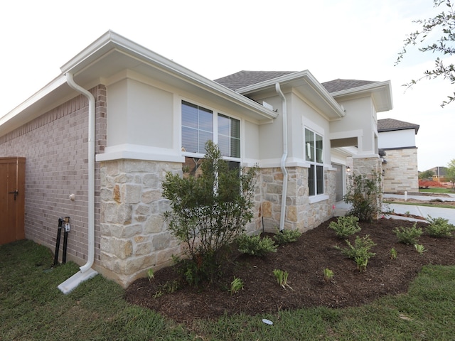 8311 Oceanmist Cove Dr, Cypress, TX 77433 - view of side of property featuring stone siding, a shingled roof, and stucco siding