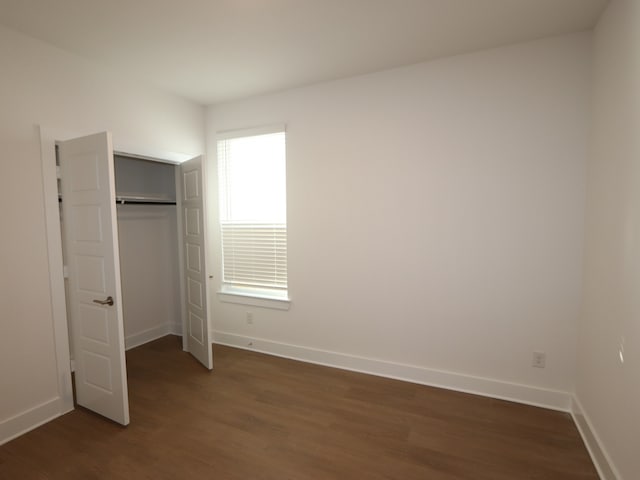 8311 Oceanmist Cove Dr, Cypress, TX 77433 - unfurnished bedroom with dark wood-style flooring, baseboards, and a closet