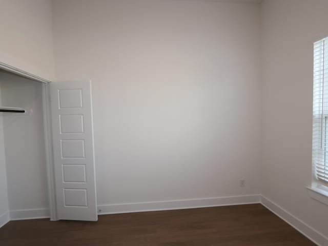 8311 Oceanmist Cove Dr, Cypress, TX 77433 - unfurnished bedroom with dark wood-type flooring, baseboards, and a closet
