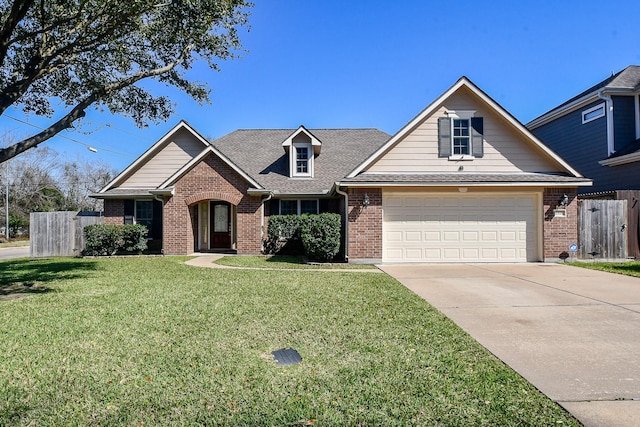 view of front facade with brick siding, an attached garage, fence, driveway, and a front lawn