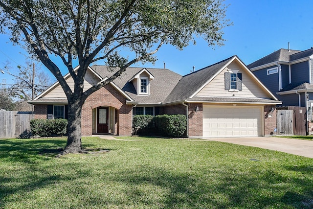 view of front of house with brick siding, an attached garage, a front yard, fence, and driveway