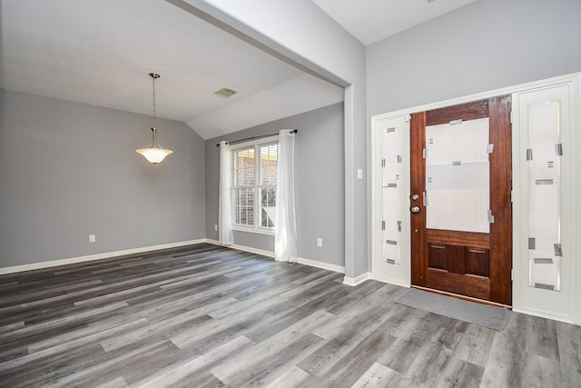 foyer entrance featuring visible vents, baseboards, vaulted ceiling, and wood finished floors