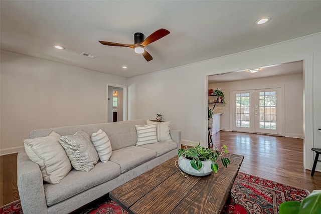 living area featuring french doors, visible vents, baseboards, and wood finished floors