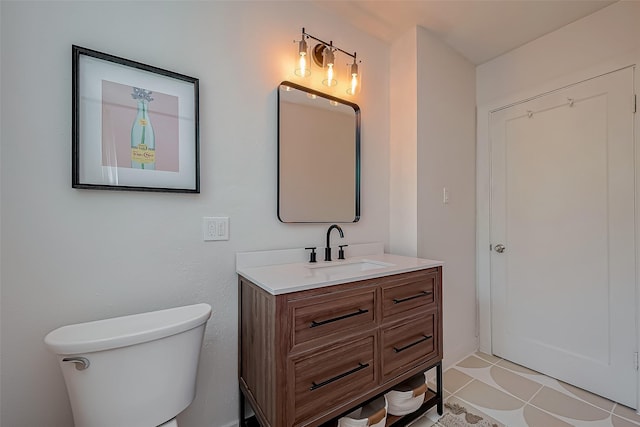 bathroom with toilet, tile patterned flooring, and vanity